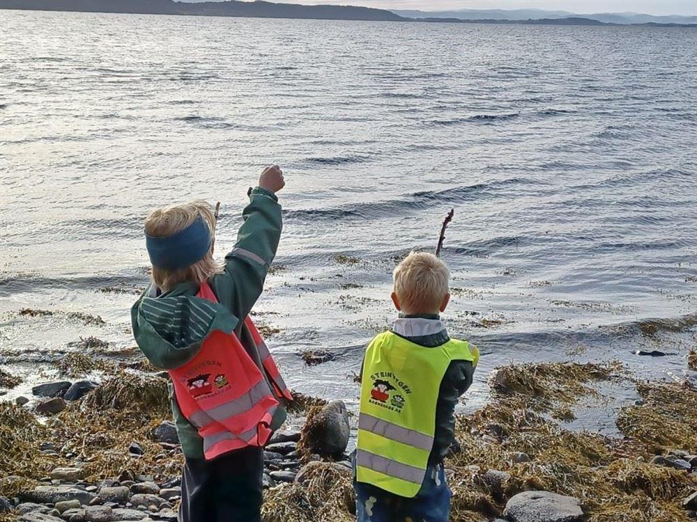 To barn som fisker i fjæra - Klikk for stort bilde