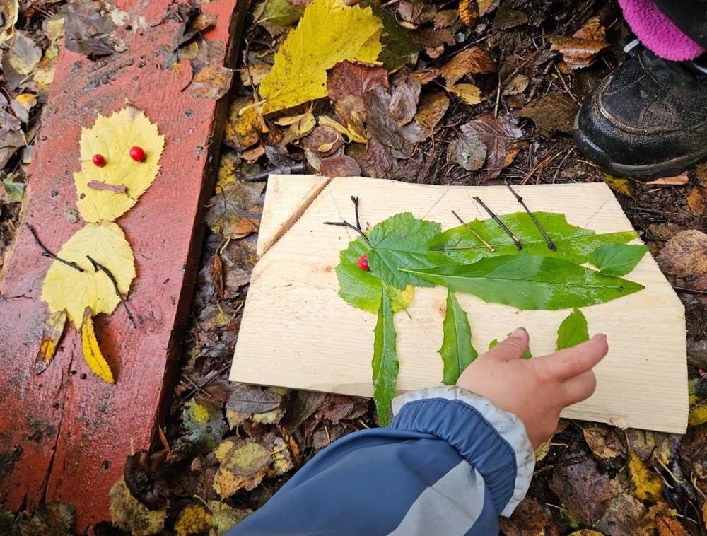 Barn leker ute og lager bilder av blad - Klikk for stort bilde